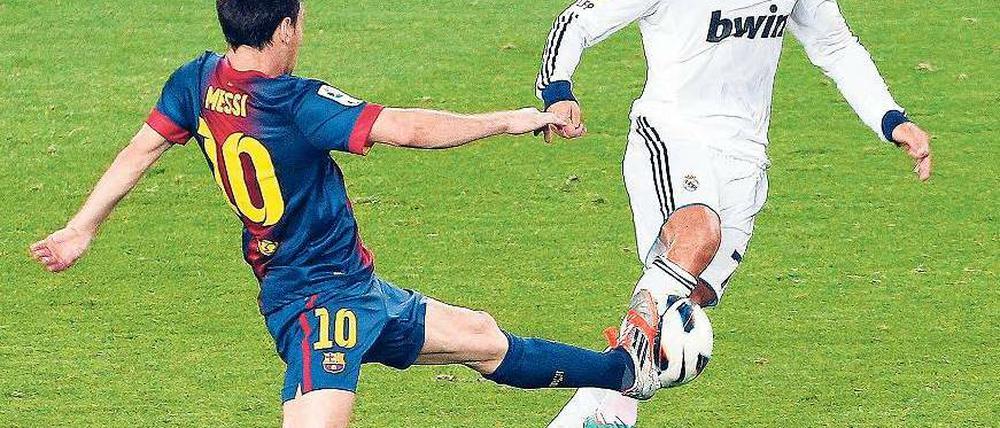 Zauberer am Werk. Messi (l.) und Ronaldo buhlen um die Gunst des Balls. Foto: dpa