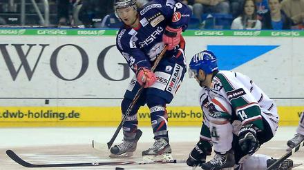Neu-Eisbär Berlins Claude Giroux (l) spitzelt den Puck an Augsburgs Tobias Draxinger vorbei.