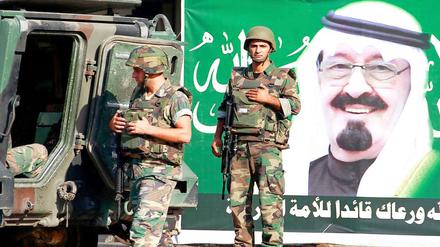 Libanesische Soldaten patrouillieren vor einem Poster von König Abdullah von Saudi Arabien. 