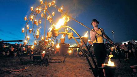 Mummenschanz mit Feuerzauber. Tontöpfe, aus denen es lodert und die mit Eisenkonstruktionen zu feurigen Skulpturen verbunden wurden, sind bei der Compagnie Carabosse eigentlich immer dabei, in diesem Fall bei ihrem Auftritt im Juli 2010 auf dem Paleo-Festival in Nyon (Schweiz). Foto: dpa