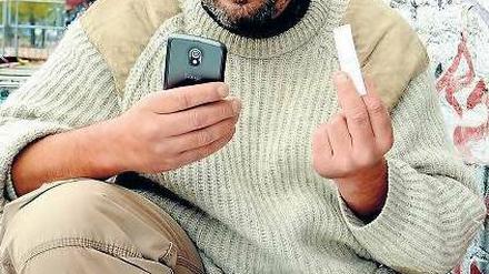 Entwickler Erich Thurner mit Handy und NFC-Tag vor seinem Büro auf dem RAW-Gelände in Berlin-Friedrichshain.