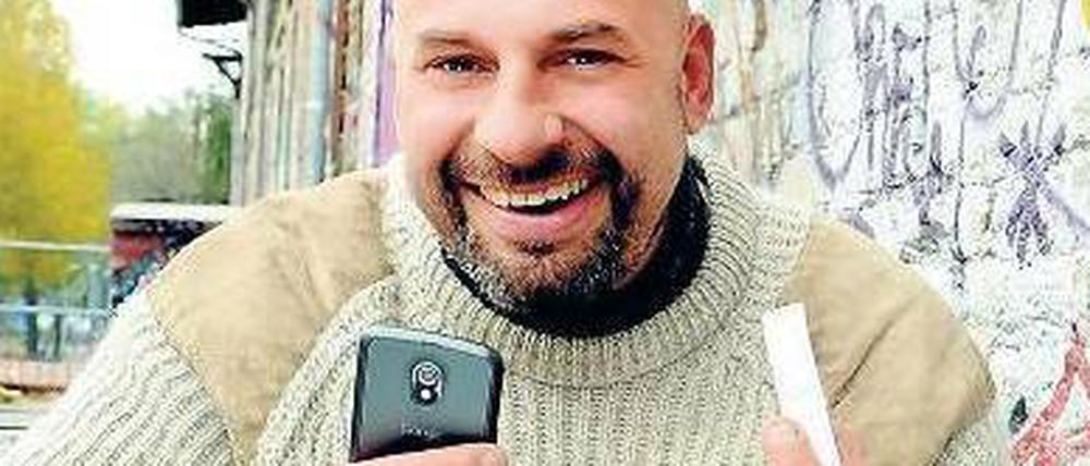Entwickler Erich Thurner mit Handy und NFC-Tag vor seinem Büro auf dem RAW-Gelände in Berlin-Friedrichshain.