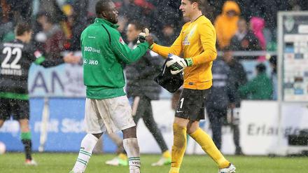 Shakehands im Schnee: Fürths Asamoah und Bremens Torwart Mielitz verabschieden sich nach dem Spiel.