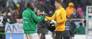 Shakehands im Schnee: Fürths Asamoah und Bremens Torwart Mielitz verabschieden sich nach dem Spiel.