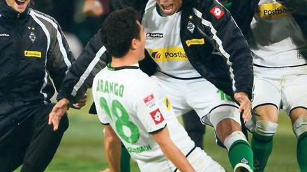 Rutsch ins Glück. Nach seinem Freistoßtor zum 3:2 für Borussia Mönchengladbach lässt sich Juan Arango von seinen Kollegen feiern. Der Venezolaner war an allen drei Treffern beteiligt. Foto: dpa