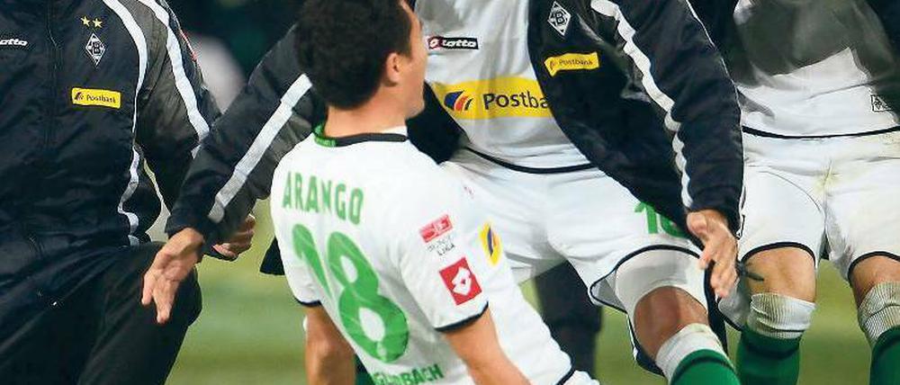 Rutsch ins Glück. Nach seinem Freistoßtor zum 3:2 für Borussia Mönchengladbach lässt sich Juan Arango von seinen Kollegen feiern. Der Venezolaner war an allen drei Treffern beteiligt. Foto: dpa