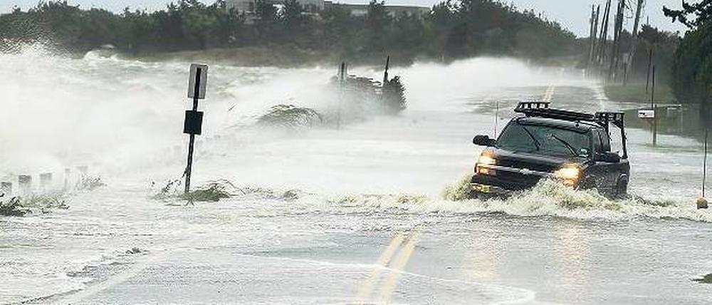 Ein Fahrer gerät in den Hamptons bei New York ins Schlingern, als die ersten von „Sandy“ aufgepeitschten Wellen das Land überschwemmen. Foto: Reuters