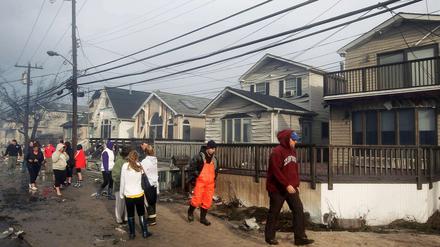 Bewohner von Breezy Point im New Yorker Stadtteil Queens schauen sich die durch "Sandy" angerichteten Schäden an. Bis zu 100 Häuser wurden in Queens durch ein Großfeuer zerstört.
