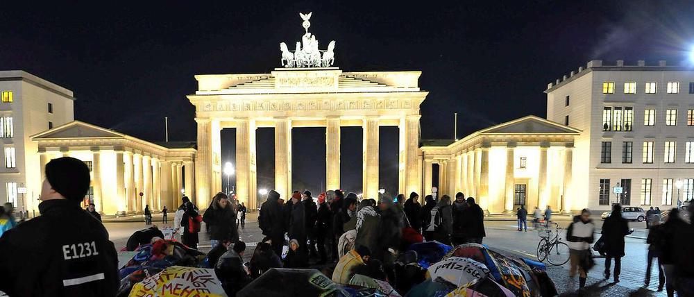 Bei eisigen Temperaturen halten die Flüchtlinge im Hungerstreik auch nachts auf dem Pariser Platz aus. Die mit Protestslogans bemalten Schirme gelten als Kunstgegenstände und dürfen deshalb bleiben.