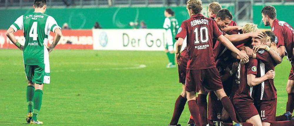 Allein in Offenbach. Während die Spieler der Kickers den 1:0-Führungstreffer bejubeln, ahnt Unions Roberto Puncec (links) schon das Pokalaus. Zuvor waren bereits Hertha BSC in der ersten und der Berliner AK in der zweiten Runde gescheitert. Foto: dpa