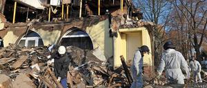 Polizisten untersuchen am 8.11.2011 in Zwickau die Überreste des Hauses der rechtsextremen Terrorzelle NSU. Ein Jahr später kritisieren Angehörige der Opfer Versäumnisse bei der Aufklärung.