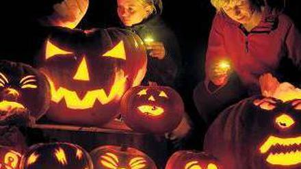 Kinder mit leuchtenden Kürbissen beim Halloween-Fest.