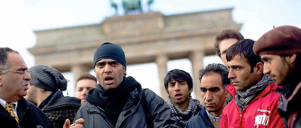 Der Übersetzer Reza (links) und der Asylbewerber Arash aus dem Iran (mitte) geben am 05.11.2012 in Berlin am Brandenburger Tor eine Pressekonferenz. Die Flüchtlinge protestieren gegen die Residenzpflicht, Sammelunterkünfte und die Asylpolitik in Deutschland.