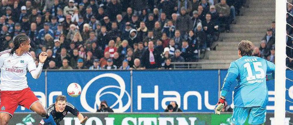 Gefahr im Anflug. Bayerns Bastian Schweinsteiger (schwarzes Trikot) schlich sich bei einer Flanke von Toni Kroos in den Rücken der Hamburger Abwehr und überwand HSV-Torwart René Adler (rechts) zur Münchener Führung. Foto: dpa
