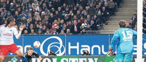 Gefahr im Anflug. Bayerns Bastian Schweinsteiger (schwarzes Trikot) schlich sich bei einer Flanke von Toni Kroos in den Rücken der Hamburger Abwehr und überwand HSV-Torwart René Adler (rechts) zur Münchener Führung. Foto: dpa