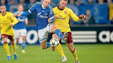 Duell der Ellbogen. Marco Höger (links) mit Arsenals Lukas Podolski. Foto: dapd