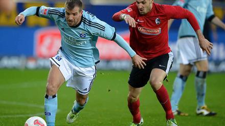 Rafael van der Vaart (l.), hier im Zweikampf mit Daniel Caligiuri, konnte seinen HSV in Unterzahl nicht zum Sieg führen. Am Ende stand ein torloses Unentschieden.