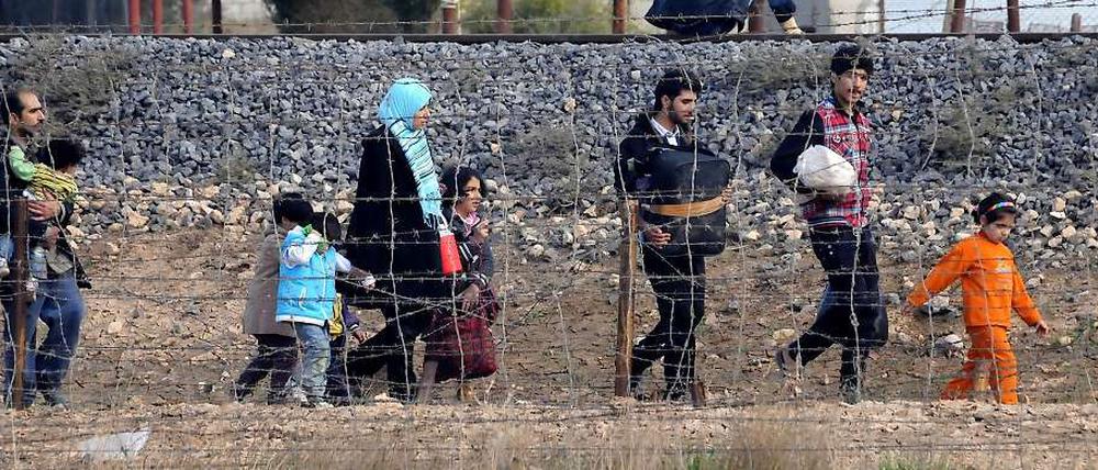 Eine Familie flieht nach Angriffen im türkisch-syrischen Grenzgebiet. 