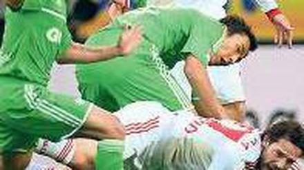 Bayer am Boden. Gonzalo Castro mit den Wolfsburgern Makoto Hasebe (Mitte) und Wolfsburgs Josue (links). Foto: dapd