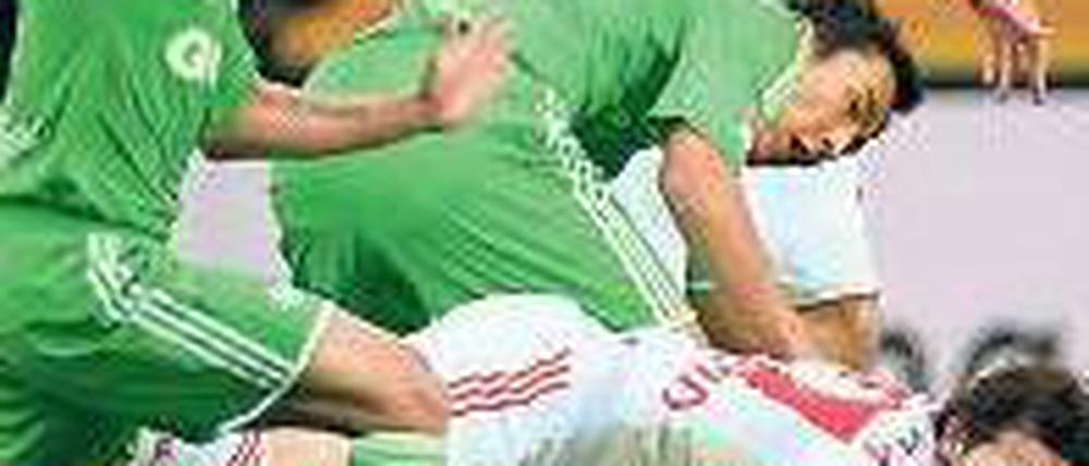 Bayer am Boden. Gonzalo Castro mit den Wolfsburgern Makoto Hasebe (Mitte) und Wolfsburgs Josue (links). Foto: dapd