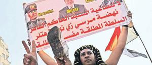 Die Volksseele kocht. Ein Demonstrant hält in Kairo ein Protestplakat gegen Mohammed Mursi hoch, das Ägyptens Staatschef mit Hitler und Mussolini vergleicht.Foto: Katharina Eglau