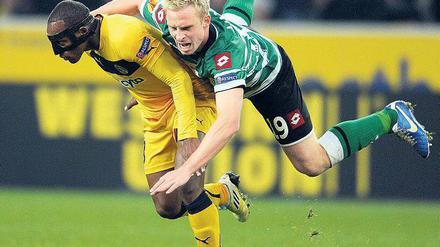 Hanke im Huckepack. Gladbachs Stürmer nutzt Carlitos als Ablagefläche. Foto: dpa