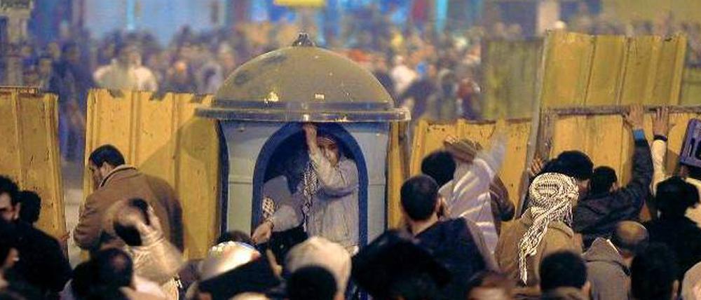 Die Front vor dem Palast. Mit Steinen und anderen Wurfgeschossen bekämpfen sich Anhänger und Gegner von Präsident Mohammed Mursi.