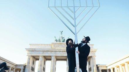 Glaubensbekenntnis. Gemeinsam haben die Rabbiner Yehuda Teichtal (rechts) und Shmuel Segal gestern auf dem Pariser Platz einen sechs Meter hohen Chanukka-Leuchter aufgestellt. Angezündet wird er aber erst am morgigen Sonntag um 18.30 Uhr. 
