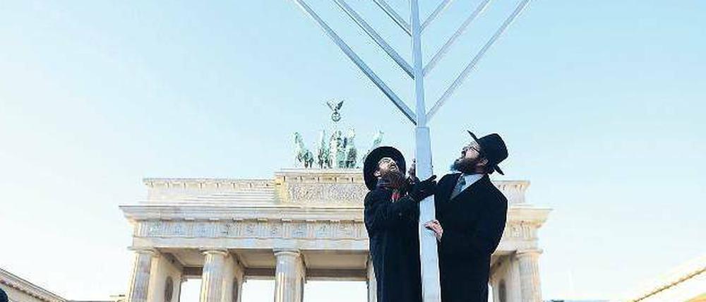 Glaubensbekenntnis. Gemeinsam haben die Rabbiner Yehuda Teichtal (rechts) und Shmuel Segal gestern auf dem Pariser Platz einen sechs Meter hohen Chanukka-Leuchter aufgestellt. Angezündet wird er aber erst am morgigen Sonntag um 18.30 Uhr. 