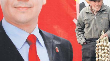 Vor einem Wahlplakat des sozialistischen Premiers Viktor Ponta verkauft ein Mann in Bukarest Knoblauch. 