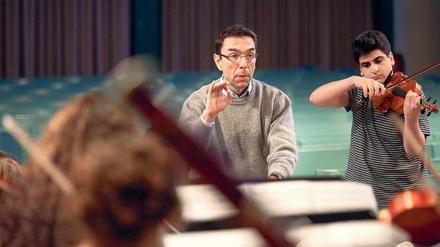 Musikalischer Einsatz. Lehrer Martin Burggaller dirigiert, sein Schüler Varoujan Simonian spielt die Geige beim Weihnachtskonzert des Arndt-Gymnasiums. Für sein langjähriges Engagement für die musikalische Bildung bekommt Burggaller am Freitag das Bundesverdienstkreuz.Foto: Christian Mang