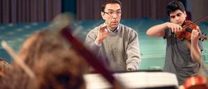 Musikalischer Einsatz. Lehrer Martin Burggaller dirigiert, sein Schüler Varoujan Simonian spielt die Geige beim Weihnachtskonzert des Arndt-Gymnasiums. Für sein langjähriges Engagement für die musikalische Bildung bekommt Burggaller am Freitag das Bundesverdienstkreuz.Foto: Christian Mang