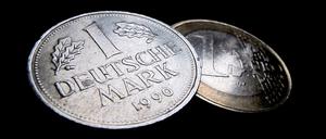 Eine Ein-Euro-Münze (r) und eine Deutsche Mark (D-Mark), aufgenommen am 17.12.2010 in Kaufbeuren (Bayern).