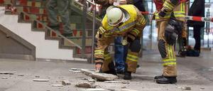 Ein heruntergefallener Betonbrocken wird inspiziert.