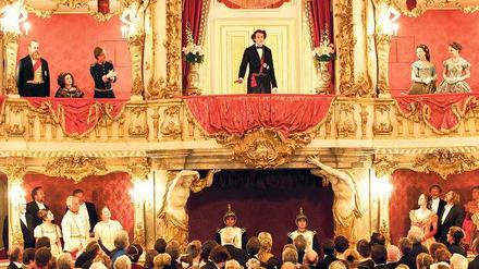 Herrscherpracht. Sabin Tambrea lässt sich als junger Ludwig in seiner Theaterloge feiern. Foto: Bavaria Film/Warner Bros.