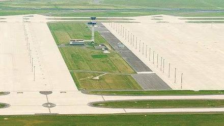 Der Platz ist jedenfalls da. Wenn der BER ausgebaut werden sollte, haben die Planer die Wiesen rund um den 72 Meter hohen Tower im Blick: Dort sollen die Satelliten entstehen. Rechts im Bild ist der neue Terminal zu erkennen. Foto: dapd