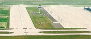 Der Platz ist jedenfalls da. Wenn der BER ausgebaut werden sollte, haben die Planer die Wiesen rund um den 72 Meter hohen Tower im Blick: Dort sollen die Satelliten entstehen. Rechts im Bild ist der neue Terminal zu erkennen. Foto: dapd