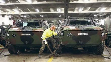 Ein Soldat kontrolliert die Sicherung eines ABC-Spürpanzers während der Verladung einer Patriot-Einheit der Bundeswehr im Hafen von Lübeck-Travemünde. Foto: dpa