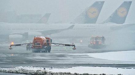 Flugzeuge im Nebel. Schneeräumer und Enteisungsfahrzeuge am Montagmorgen auf dem Flughafen Frankfurt. 
