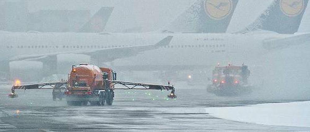 Flugzeuge im Nebel. Schneeräumer und Enteisungsfahrzeuge am Montagmorgen auf dem Flughafen Frankfurt.