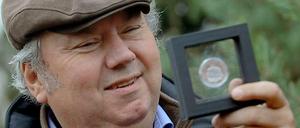 Mit Mütze und Münze. Blaszkiewitz kann pro Jahr rund 2,94 Millionen Gäste allein im Zoo begrüßen - da bleibt einiges hängen. Hier zeigt er eine Art Fanartikel, die Gedenkmünze "Knut - Der Träumer". 