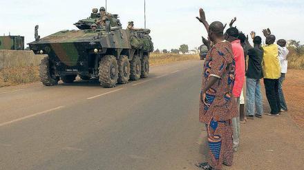 Malische Bürger winken am Flughafen von Bamako einem französischen Militärkonvoi zu.