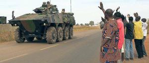 Malische Bürger winken am Flughafen von Bamako einem französischen Militärkonvoi zu.