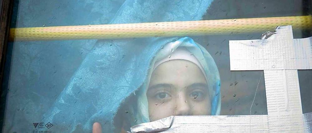 Ein syrisches Mädchen blickt aus einem Busfenster. Das Kind lebt schon seit Monaten in einem Flüchtlingslager an der syrisch-türkischen Grenze.