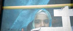 Ein syrisches Mädchen blickt aus einem Busfenster. Das Kind lebt schon seit Monaten in einem Flüchtlingslager an der syrisch-türkischen Grenze.