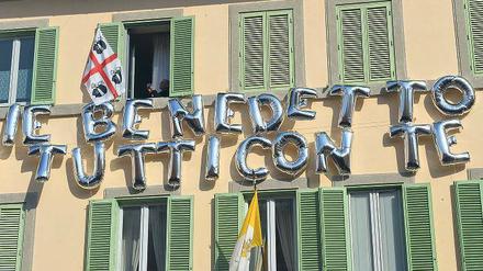 Willkommensgruß. In Castel Gandolfo, wo Benedikt XVI. in der päpstlichen Sommerresidenz die kommenden Wochen verbringen wird, ist ein Haus mit Ballons geschmückt – und dem Schriftzug „Benedikt, alle sind mit dir“. Foto: Vincenzo Pinto/AFP