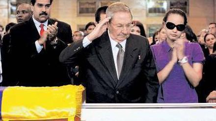 Mit militärischem Gruß: Kubas Präsident Raul Castro (M.) erweist Hugo Chávez die letzte Ehre. Dessen Tochter Rosa und Interims-Staatschef Maduro applaudieren. Foto: Reuters