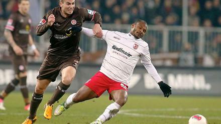 Kraftakt: St. Paulis Dennis Daube (l.) setzt sich gegen Regenburgs Julian De Guzman durch.