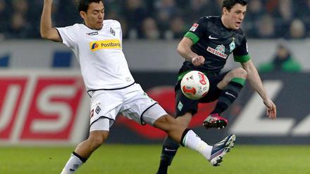 Der Mönchengladbacher Juan Arango (l.) und der Bremer Lukas Schmitz kämpfen um den Ball.