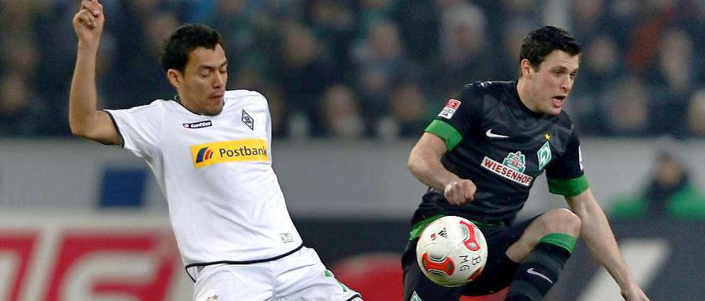 Der Mönchengladbacher Juan Arango (l.) und der Bremer Lukas Schmitz kämpfen um den Ball.